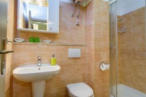 a bathroom with a sink and a toilet and a shower at Abba Apartments in Mali Lošinj