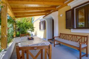 a patio with two benches and a table and chairs at Abba Apartments in Mali Lošinj