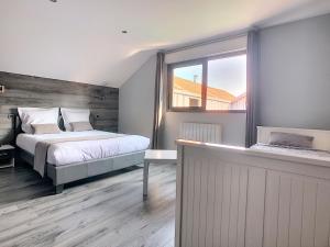 um quarto com uma cama e uma janela em Le Bord de Sèvre em Saint-Laurent-sur-Sèvre
