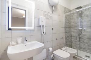 bagno bianco con lavandino e servizi igienici di San Marco Hotel a Napoli