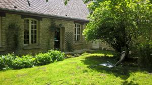 a metal chair sitting in the grass in front of a house at l'atelier in Parnes