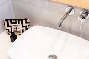 La salle de bains est pourvue d'un lavabo blanc et d'un robinet. dans l'établissement Golden Sand Paros, à Chrissi Akti