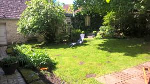 a yard with a chair in the grass at l'atelier in Parnes