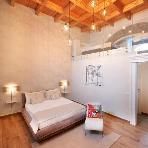 1 dormitorio con 1 cama y 1 silla en La Fornace Relais & Spa, en Castellammare di Stabia