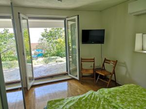 een slaapkamer met een bed en een glazen schuifdeur bij Luxury apartment with own terrace and sea view in Trogir