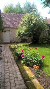 a garden with pink flowers next to a garage at l'atelier in Parnes +2 photos