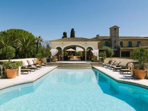 a swimming pool with chairs and a gazebo at Son Julia Country House & Spa in Llucmajor