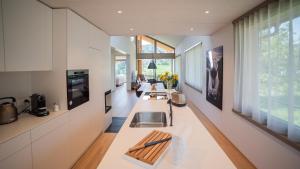 a kitchen with white cabinets and a long counter top at Seaside-Lodge, Top Apartment in Spiez