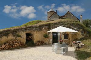 einen Regenschirm vor einem Haus in der Unterkunft La Grotte du Moulin in Noyers-sur-Cher