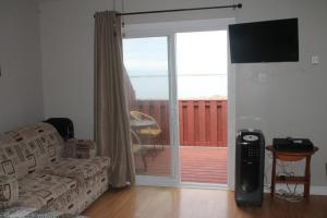 sala de estar con sofá y puerta corredera de cristal en Robbins by the Sea en Bonavista