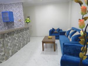 Sala de estar con sofás azules y mesa de centro en Apartments Sunny Sky RedSeaLine Hurghada, en Hurghada
