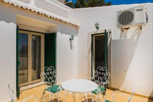 a patio with a white table and chairs at Akivillas Albufeira Nature in Albufeira