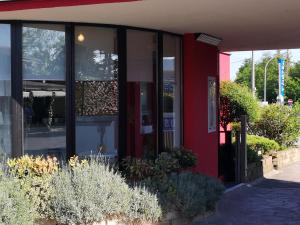 a red and black building with a glass door at 7MOTEL - Settimotel in Settimo Milanese