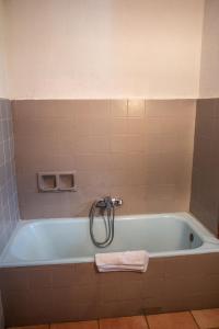 a bath tub in a bathroom with a towel at Hotel Relais Saint Louis in Saint-Martin-Vésubie