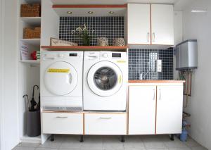 a white laundry room with a washer and dryer at Old Airline Guesthouse in Höfn