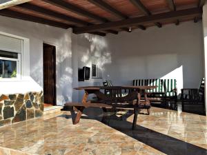 eine Terrasse mit einem Holztisch und einer Bank in der Unterkunft Casa Ananda y Casa Rengue in Conil de la Frontera