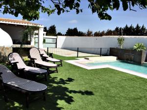 eine Gruppe von Stühlen neben einem Swimmingpool in der Unterkunft Casa Ananda y Casa Rengue in Conil de la Frontera