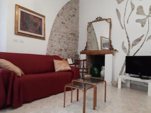 un soggiorno con divano rosso e specchio di La casa del Largo a Venosa
