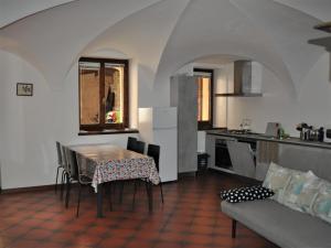 eine Küche mit einem Tisch und einem Sofa in einem Zimmer in der Unterkunft Appartamento Le Volte in Toscolano-Maderno