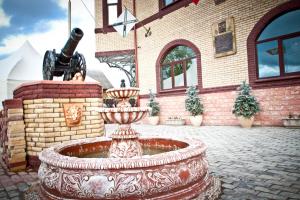 a fountain in front of a building with a statue at Petrovsky Dvorik in Vozdvizhenskoye
