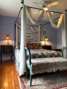 Blue Gables Bed and Breakfast في شلالات نياجارا: غرفة نوم بسريرين وسرير مظلة