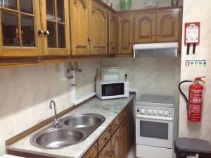 a small kitchen with a sink and a microwave at Vintage apartment Milfontes in Vila Nova de Milfontes