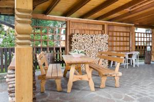 a wooden table and two benches on a patio at Jägerhaus in Pellizzano