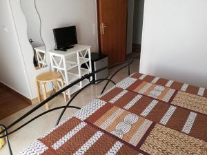 a bedroom with a bed and a desk with a computer at B&B Vie En Rose in Porto Cesareo