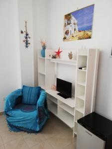 a room with a chair and a desk with a computer at B&B Vie En Rose in Porto Cesareo