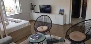 a living room with two chairs and a tv at Lux - Apartment BCN in Budva
