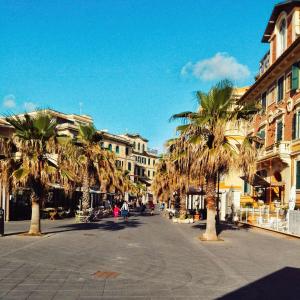 una calle de la ciudad con palmeras y edificios en B&B Lido Liberty - "L'abbraccio di Klimt" en Lido di Ostia