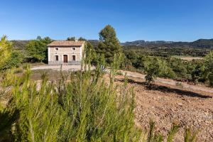 an old house in the middle of a field at Masia Villa Pilar in Valderrobres