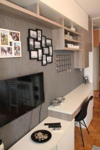 uma sala de estar com uma secretária e uma televisão num quarto em Very central cozy apartment em Novi Sad