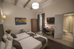 una camera d'albergo con due letti e una scrivania di Europa Hotel a Sliema