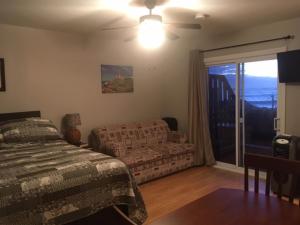 a bedroom with a bed and a couch and a window at Robbins by the Sea in Bonavista