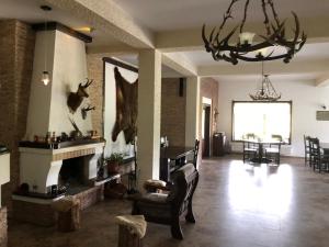 a living room with a fireplace and a chandelier at Valea Salbatica in Şinca Nouă +136 photos