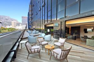 a balcony with chairs and tables on a building at Penthouse Henning@The Onyx in Cape Town