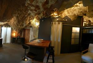 ein Zimmer in einer Höhle mit einem Tisch und Stühlen in der Unterkunft La Grotte du Moulin in Noyers-sur-Cher