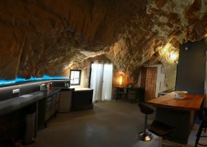 eine Küche in einer Höhle mit einer Steinwand in der Unterkunft La Grotte du Moulin in Noyers-sur-Cher