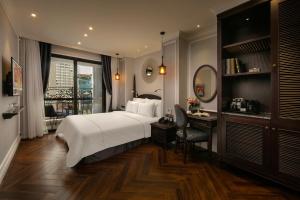 a bedroom with a bed and a desk and a mirror at Canary Hotel in Hanoi