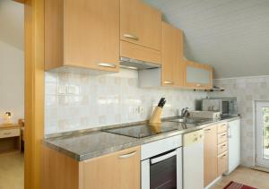 a kitchen with wooden cabinets and a counter top at Put Maslina 7 in Savudrija