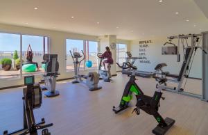 a gym with treadmills and exercise bikes in a room at H10 Vintage Salou - Adults Only in Salou