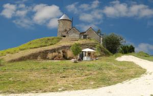 une île avec un château au sommet d'une colline dans l'établissement Le Moulin de la Motte Baudoin, à Noyers-sur-Cher