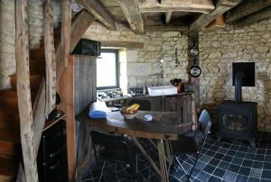 a kitchen with a table and a stove in a room at Le Moulin de la Motte Baudoin in Noyers-sur-Cher