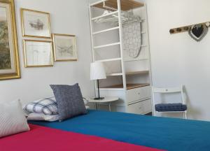 a bedroom with a bed and a desk and shelves at Little Blue House in Marsalforn