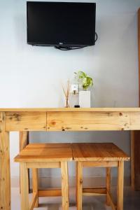 un escritorio de madera con una TV encima en Louto Dmell Guesthouse, en Sanur