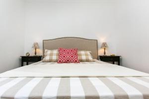 - une chambre avec un grand lit blanc et un oreiller rouge dans l'établissement Belem! Charming 2 Bedroom Apartment w terrace, Wifi & free street parking, à Lisbonne