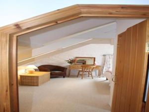 uma sala de estar com uma abertura para um quarto com um sótão em Church Barn em Harberton
