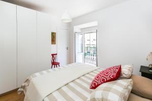 - une chambre avec un lit doté d'oreillers rouges et blancs dans l'établissement Belem! Charming 2 Bedroom Apartment w terrace, Wifi & free street parking, à Lisbonne