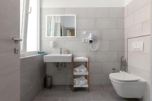 a bathroom with a sink and a toilet and a mirror at Preziosa in Pula